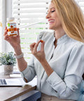 A woman holding Herbion Turmeric Gummies with Ginger