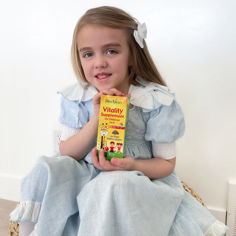 A child holding Herbion Vitality Supplement for Children